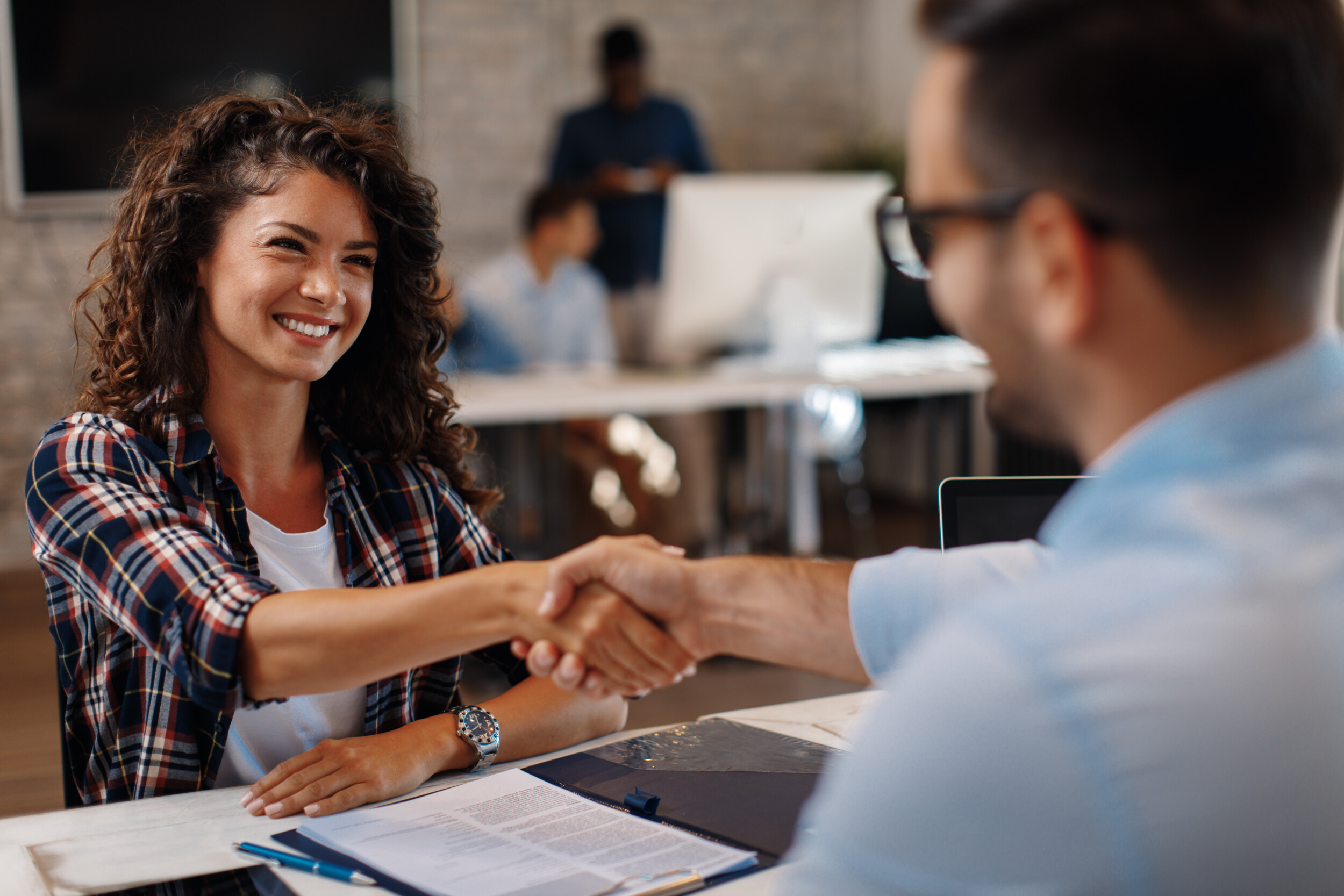 A man and a woman in an office high fiving each other